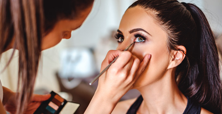 Makeup artist applying eyeshadow on a beautiful girl